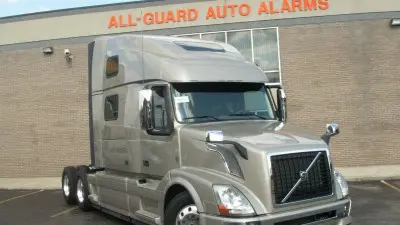 A truck parked in front of a building with the words " all-guard auto alarm ".